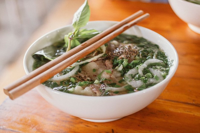 Tô phở bò nóng bên khung cửa nhìn cây xanh