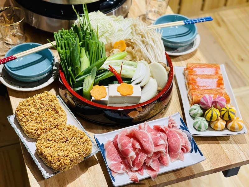 Nồi lẩu rau với mì, thịt bò thái mỏng và các loại viên thả lẩu