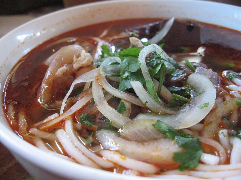 Cận cảnh tô bún bò nước đỏ có thịt bò, hành tây, rau thơm