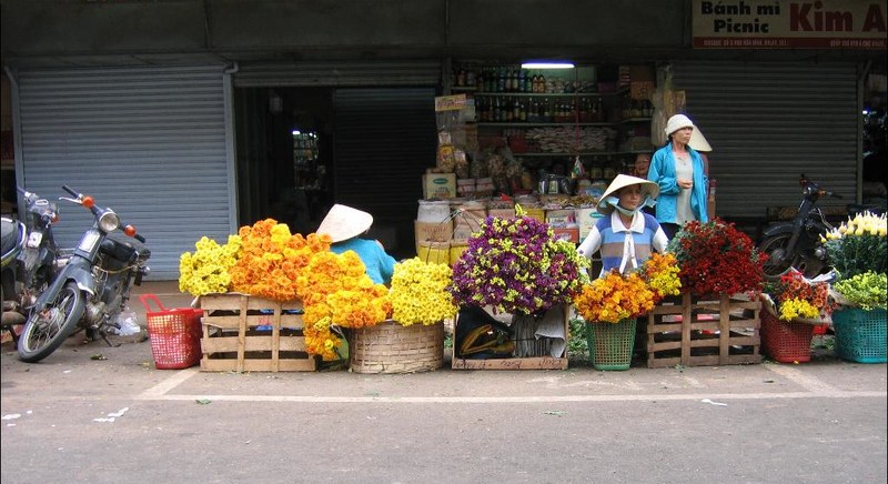 Mấy gánh hoa cúc, hoa vàng bày bán trước dãy nhà ở Đà Lạt