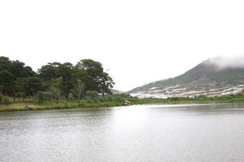 Hồ Than Thở ngày nhiều mây, phía xa là đồi có nhà kính