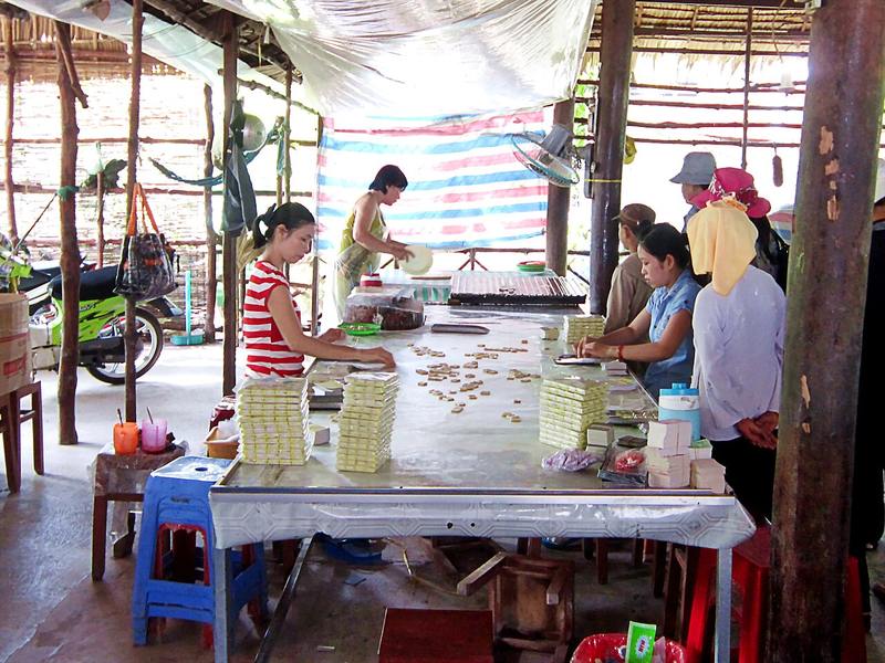 Người dân gói kẹo dừa trong một cơ sở trên cồn Quy