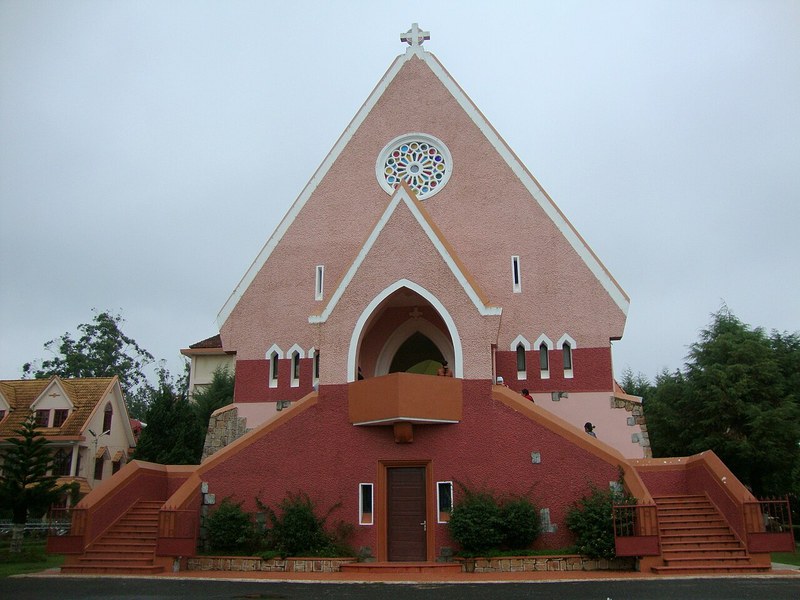Mặt tiền tam giác của nhà thờ Domaine de Marie với cửa sổ hoa hồng