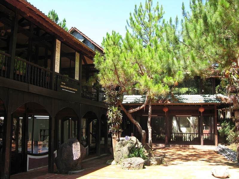 Dãy nhà gỗ và cây thông trong khuôn viên XQ Sử Quán